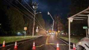 Photo of emergency workmen repairing owned power lines on highway.