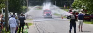 Photo of Norfolk, Connecticut's newest fire truck being christened with hoses.