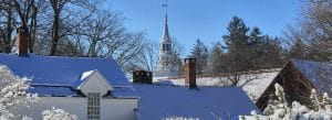 Photograph of snowy rooftops, Norfolk, Connecticut, with the congregational church steeple in the background.