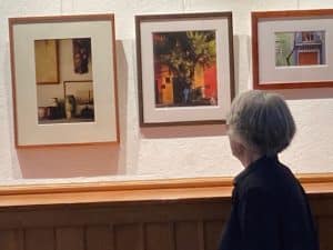 Photo of a woman looking at paintings being shown at the Norfolk, Connecticut, library.