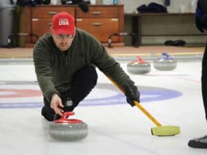 Photo of a man curling at the Norfolk, Connecticut, curling club.