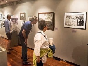 Photo of visitors looking at an exhibit in the Norfolk, Connecticut, historical society museum.