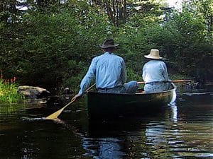 Photo of two people paddling a canoe on Wood Creek Pond, Norfolk, Connecticut.