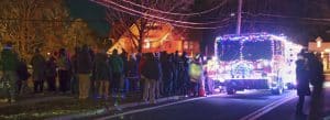 Photo of a crowd watching the lighted fire truck bring Santa to the village green for the Christmas tree lighting ceremony, Norfolk, Connecticut.