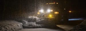 Photograph of one of the Town of Norfolk, Connecticut, snowplows clearing the road at night.