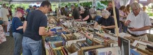 Photo of people choosing books under the tent at the 2026 Norfolk Library book sale